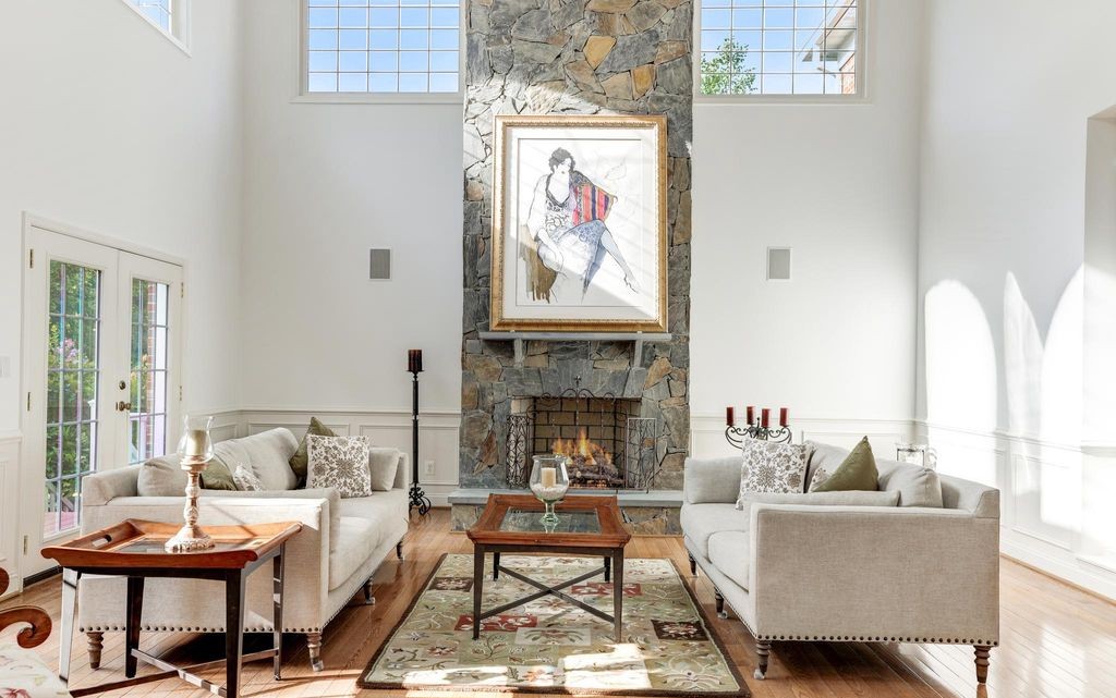 Two-story stone fireplace living room, representative of the luxury homes Eileen represents
